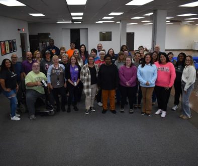 Group photo of DON Services team members in a modern office setting.